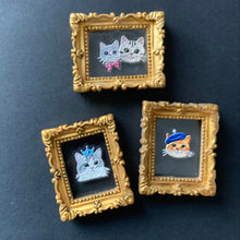 Load image into Gallery viewer, Three small decorative framed art pieces with ornate gold borders, each featuring a different cat illustration on a dark background, arranged on a dark surface.