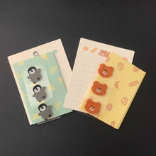 Load image into Gallery viewer, Two small decorative sets of notepaper and envelopes on a dark background. One has a mint green background with yellow fruit patterns and three gray penguin decals attached.
