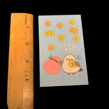 Load image into Gallery viewer, A small illustrated pochibukuro envelope with a cartoon bird, bag, and floating gold coins on a pale blue background, placed next to a wooden ruler showing 4.2 inch size on a dark surface.