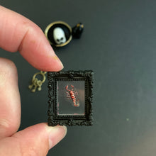 Load image into Gallery viewer, Small 1 inch framed picture of a scorpion held between fingers against a dark background