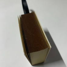 Load image into Gallery viewer, Bookworm's Holiday Ornament. The ornament is an open book; there's space to write a special message or add a personal touch. It's a perfect addition to your holiday decor, especially for book lovers and literary enthusiasts.
