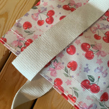 Load image into Gallery viewer, Cream canvas Kawaii cherry tote bag with embroidered red and pink cherries and purple bows, featuring a foldable and portable design for shopping