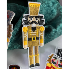 Load image into Gallery viewer, Gold Nutcracker Patch. Iron On. Detailed and colorful nutcracker designs. Customize dance bags, jeans, hoodies, or coats. Sew them onto pillows, scarves, or any material for some instant holiday fun! elementah.com