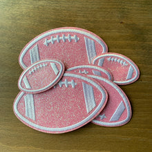 Load image into Gallery viewer, 3 pack embroidered glitter football iron-on patch set for cheer, football fans. Displayed on wood table.