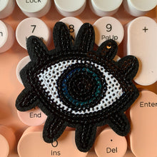 Load image into Gallery viewer, Set of 2 Turkish Evil Blue Sequin Eye Iron-On Patches with playful lash detailing, displayed on a wooden table. Each patch measures approximately 2.5 inch, perfect for customizing jeans, bags, shoes, and DIY craft projects with vibrant blue sequins.