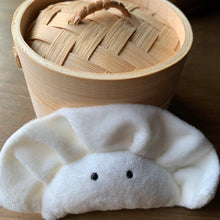 Load image into Gallery viewer, Plush Wonton dumpling keychain bag charm. White fleece with black cartoon eyes. shown with bamboo steam basket on wood table.