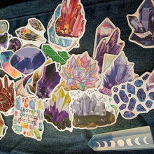 Load image into Gallery viewer, This pack of crystal geode stickers adds a touch of sparkle and natural beauty to your belongings! This pack includes 50 high-quality stickers featuring realistic and graphic designs of different types of geodes.