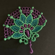 Load image into Gallery viewer, Decorative lace patch with green and purple design on a black background