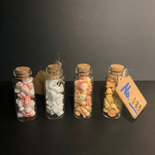 Load image into Gallery viewer, Four small glass vials with cork stoppers, each filled with faux foam prop teeth, arranged vertically on a dark surface. One vial has a small paper tag attached with the handwritten text 'No. 033
