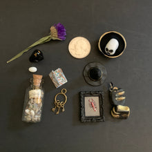 Load image into Gallery viewer, Collection of small decorative items on a dark surface
