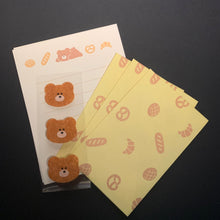 Load image into Gallery viewer, Three small brown teddy bear-shaped items on a white backing card, with three pale yellow sheets featuring peach food icons arranged on top, photographed on a dark surface.
