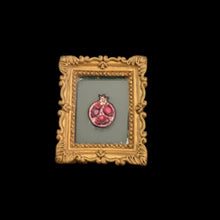 Load image into Gallery viewer, Small decorative item with a gold frame and red center on a black background
