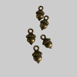 Bronze acorn-shaped charms on a white background