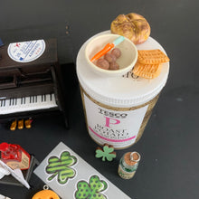 Load image into Gallery viewer, Close view of the miniature upright piano with Ireland and New York decals, mug, and shamrock details
