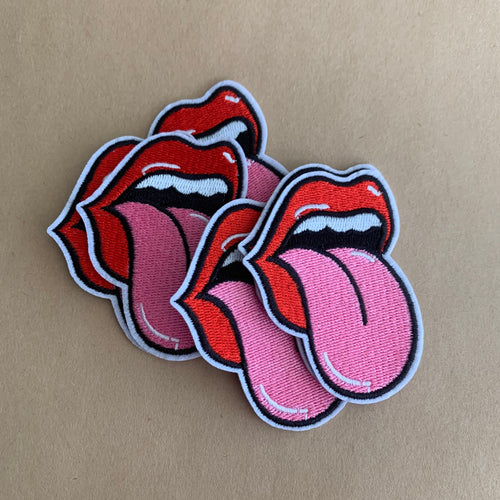 Red lips and tongue iron on patch on kraft background.