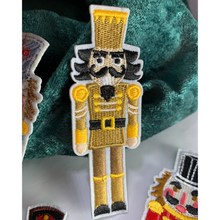 Load image into Gallery viewer, Gold Nutcracker Patch. Iron On. Detailed and colorful nutcracker designs. Customize dance bags, jeans, hoodies, or coats. Sew them onto pillows, scarves, or any material for some instant holiday fun! elementah.com
