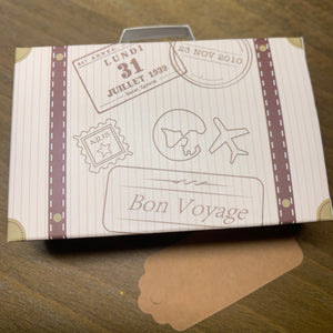 Brown World Travel Party Favor Gft Box. Shown on wood table. Kraft paper tag and jute hanger