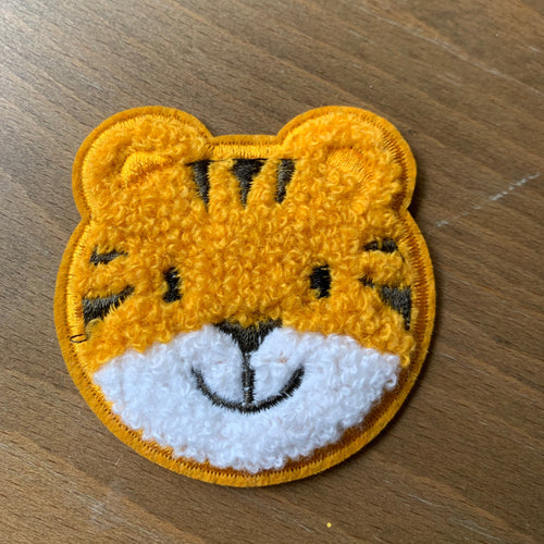 Baby Tiger patch embroidered glue on applique for kids clothes, diy. displayed on wood table. 