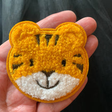 Load image into Gallery viewer, Baby Tiger patch embroidered glue on applique for kids clothes, diy. displayed on hand. 
