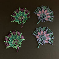 Four embroidered lace patches on a dark background