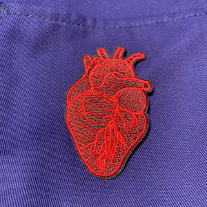 red anatomical heart patch on blue cloth