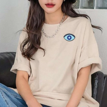 Load image into Gallery viewer, teal magic evil eye patch on tee shirt worn woman dark hair and silver chain
